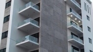A multi-story building with balconies, large windows, and a modern architectural design. - Condos TT (Mazatlán)