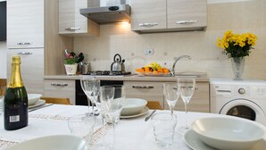 A modern kitchen with a dining area set for a meal. - GREGORY BIG FAMILY (Rome)
