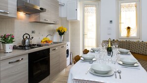 A modern kitchen with a dining area set for a meal. - GREGORY BIG FAMILY (Rome)