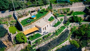 An aerial view of a small, stone building with a flat roof, surrounded by greenery and a small pool. - Casa Meraviglia Ravello (RAVELLO)