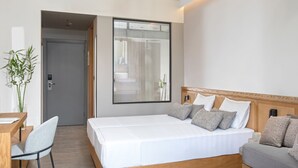 Une chambre d’hôtel moderne, dotée d’un grand lit, d’un bureau et d’une chaise.