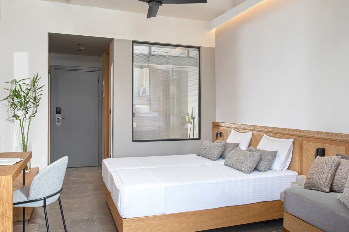 Une chambre d’hôtel moderne, dotée d’un grand lit, d’un bureau et d’une chaise.