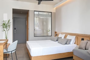 Une chambre d’hôtel moderne, dotée d’un grand lit, d’un bureau et d’une chaise.