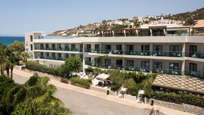 Un hôtel à plusieurs étages doté de balcons, d’un espace piscine et offrant une vue sur la mer.