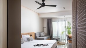 Une chambre d’hôtel moderne avec deux lits, un ventilateur de plafond, un bureau et une vue sur l’extérieur.