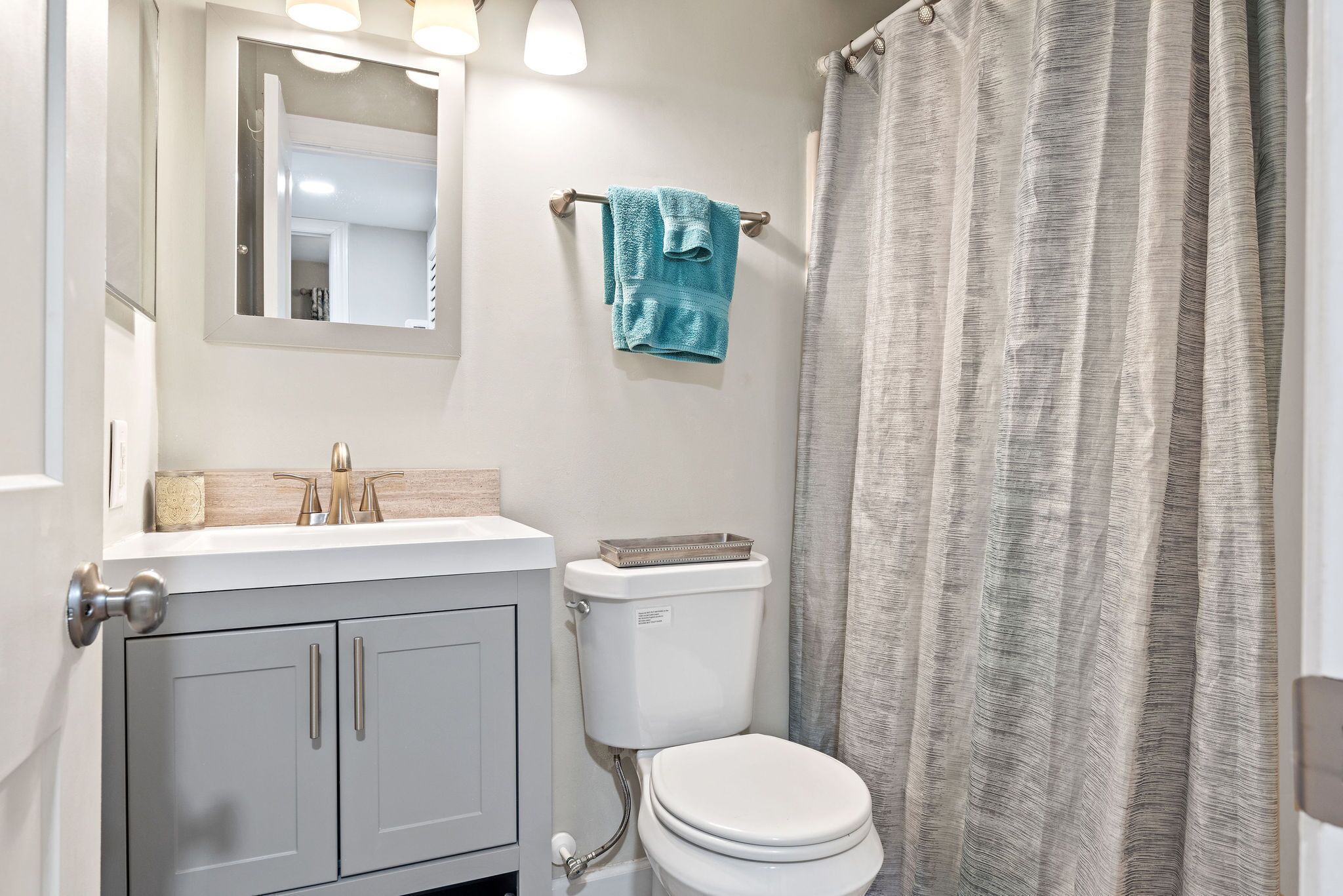 Une salle de bain avec des toilettes, un lavabo et un miroir.