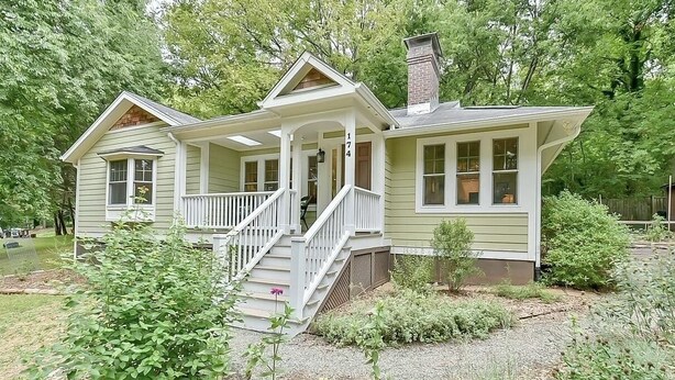 A two-story house with a porch and a chimney.