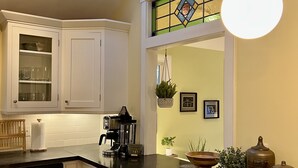 A kitchen with white cabinets, a coffee maker, and a skylight.