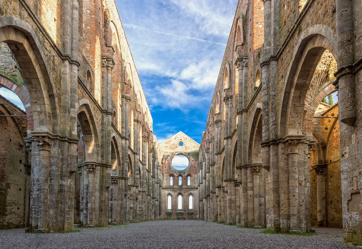 An ancient stone building with arched doorways and a central dome.