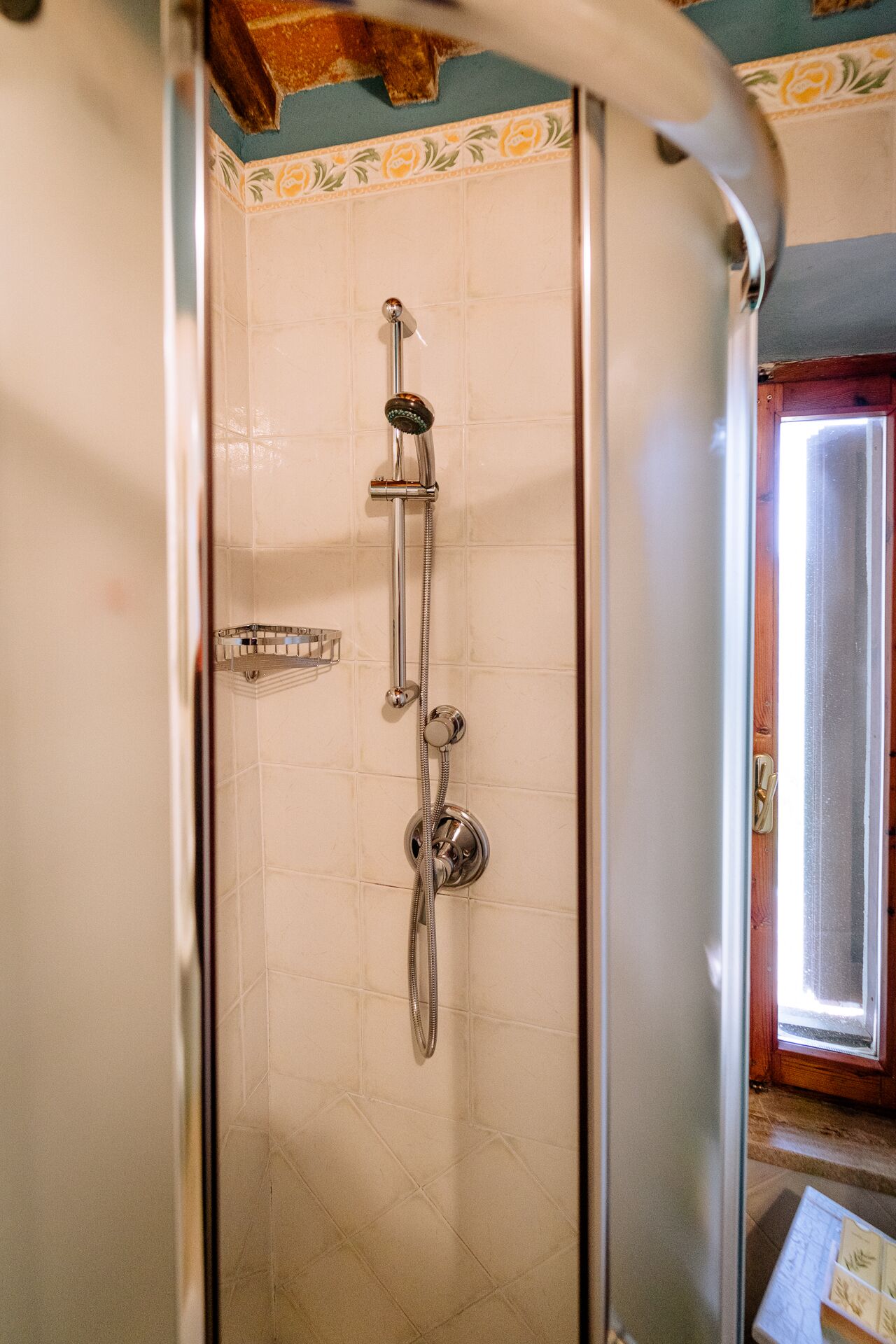 Une salle de bain avec une douche, un porte-serviettes et une porte dotée d’une poignée.