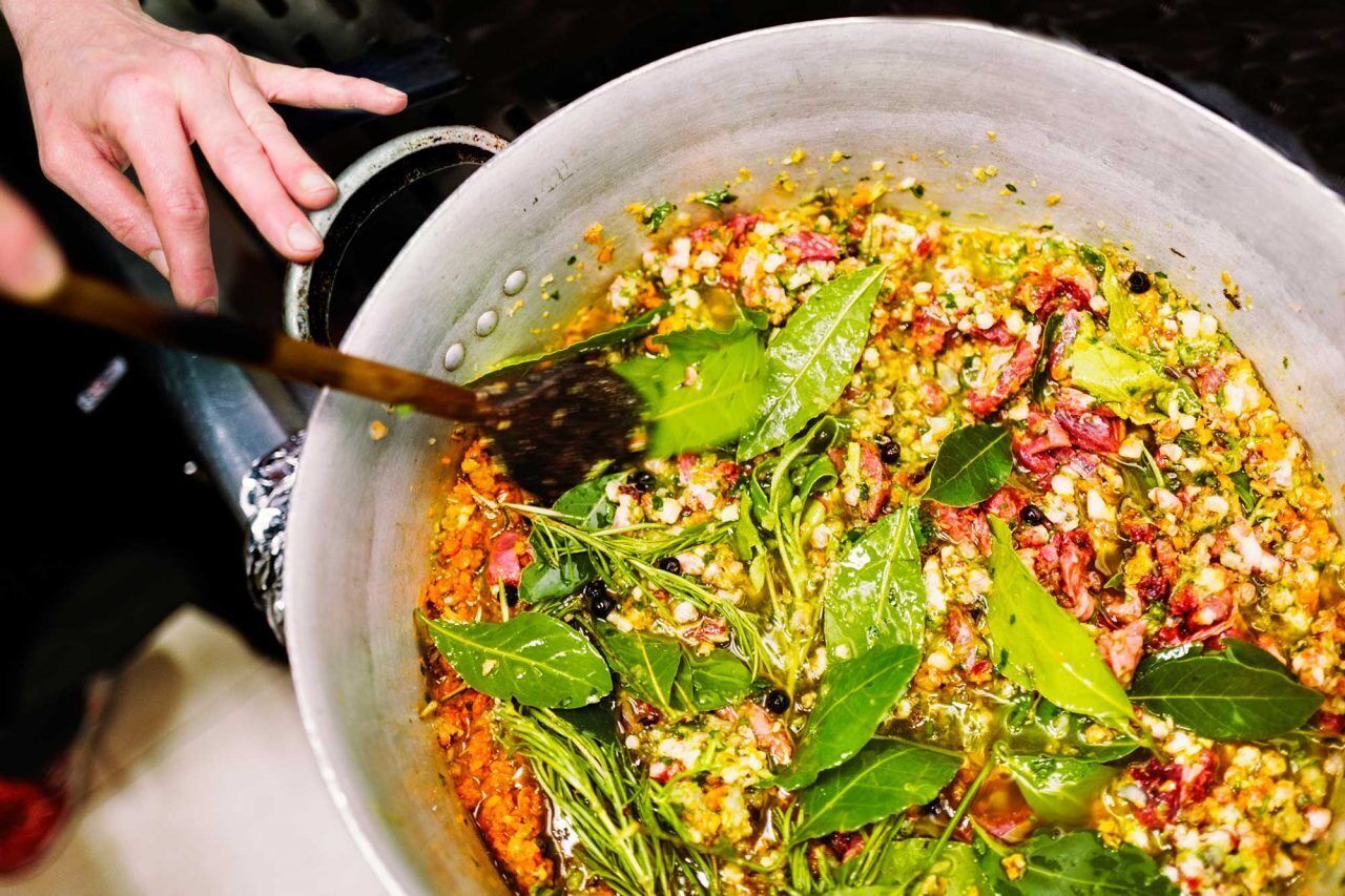 A large pot with a variety of ingredients being stirred.