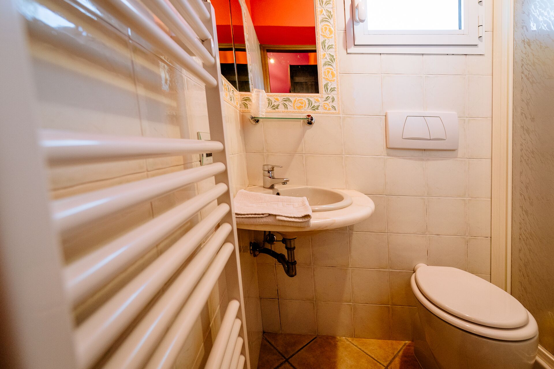 Une salle de bain avec un lavabo blanc, des toilettes et un porte-serviettes.