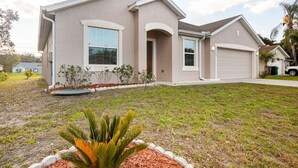 A single-story house with a garage, a front porch, and a well-maintained lawn. - Modern 4 Bdr Home near Tradition Town Center (Port St. Lucie)