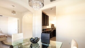 A modern dining area with a glass table, black chairs, and a decorative bowl. - Modern 4 Bdr Home near Tradition Town Center (Port St. Lucie)