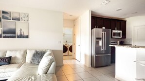 A modern kitchen with stainless steel appliances, a white countertop, and dark cabinets. - Modern 4 Bdr Home near Tradition Town Center (Port St. Lucie)
