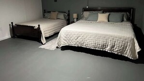 Un dormitorio con dos camas, un ventilador de techo y una lámpara de pared.