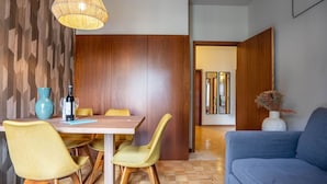 Ein moderner Essbereich mit einem Holztisch, gelben Stühlen und einer blauen Vase.