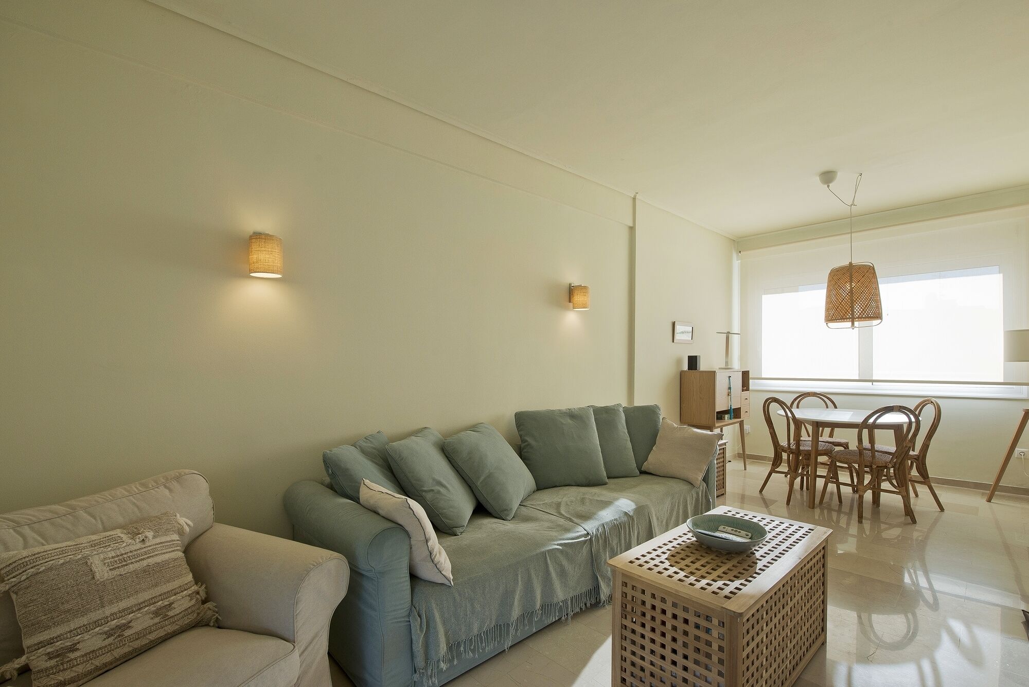 Ein Wohnzimmer mit einer Couch, einem Couchtisch und einem Essbereich mit Tisch und Stühlen.