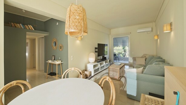 A modern living room with a dining area, a TV, and a large window. - LucyZen! Stylish Apt, Athenian Riviera, near beach (Vouliagmeni)