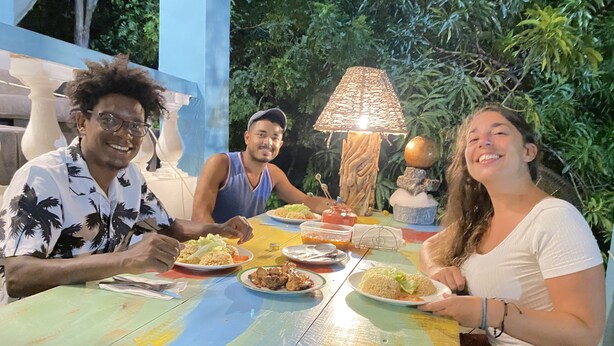 A group of people dining at a colorful table with various dishes. - The Water Melon House (Samaná)