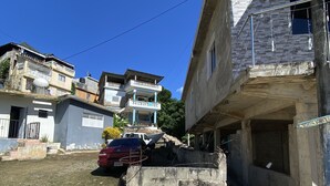 A residential area with houses, a parked car, and a construction site. - The Water Melon House (Samaná)