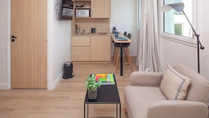 A compact living space with a kitchenette, a dining area, and a seating area with a sofa and a lamp. - Finestate Coliving Mairie d'Issy  (Issy-les-Moulineaux)