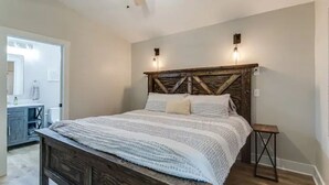 Ein Schlafzimmer mit einem hölzernen Bett, einem Deckenventilator und zwei Wandleuchten.
