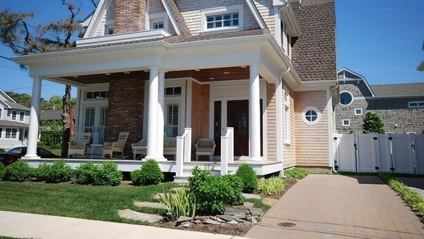 A two-story house with a covered porch, a brick chimney, and a well-maintained lawn. - Beach luxury at it's best!! (Rehoboth Beach)