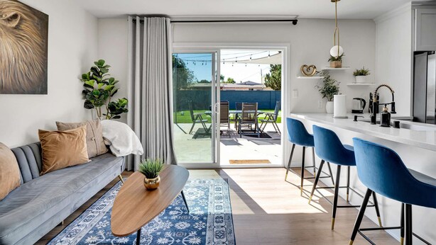 Un salon moderne avec un canapé, une table basse et une vue sur le jardin arrière.