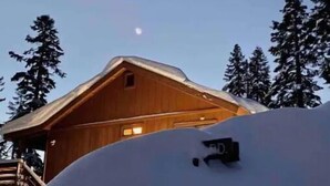 A wooden cabin with a sloped roof, surrounded by snow-covered trees. - 5 Star Upscale Unit Near Canyon Lodge (Mammoth Lakes)