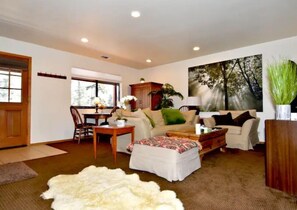 Relax in this inviting living room with a sofa, dining area, and large window.