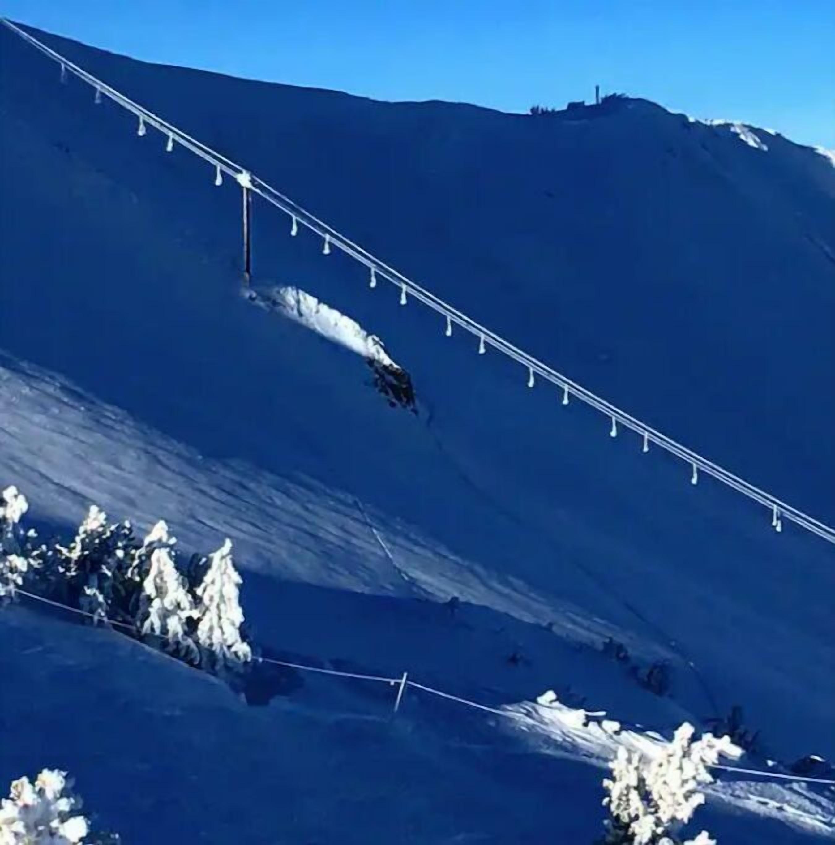 A snowy mountain slope with a ski lift.