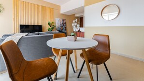 A modern living room with a grey sofa, a round white table, and brown leather chairs. - Anahuac Apartments by VH (Mexico City)