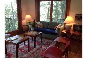 Relax in a serene space with a comfortable seating area, large windows, and a TV.