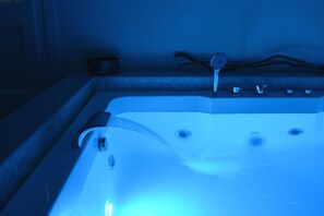 A bathtub with a handheld showerhead and a faucet.