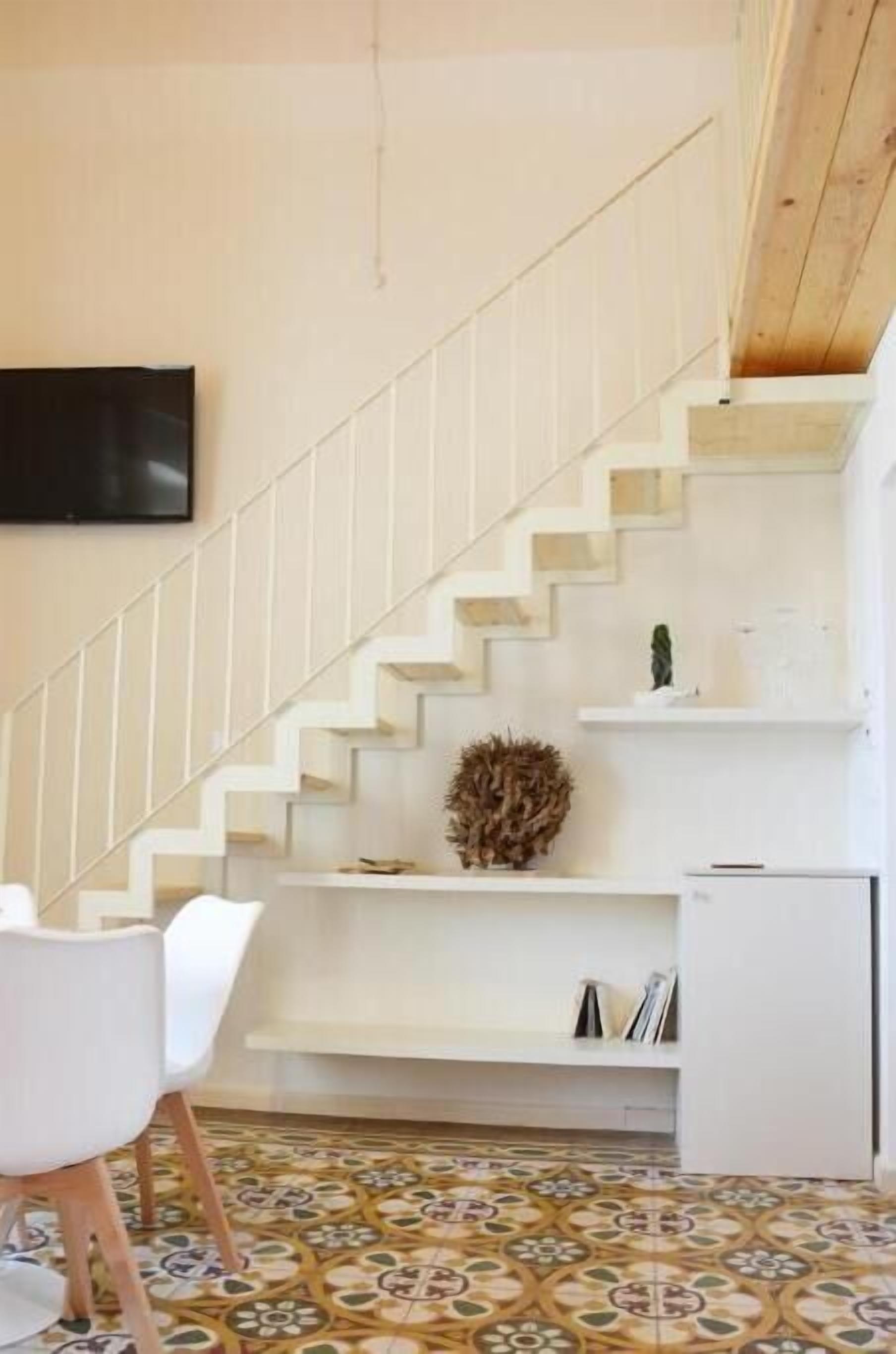 A staircase with white railings and a patterned floor.