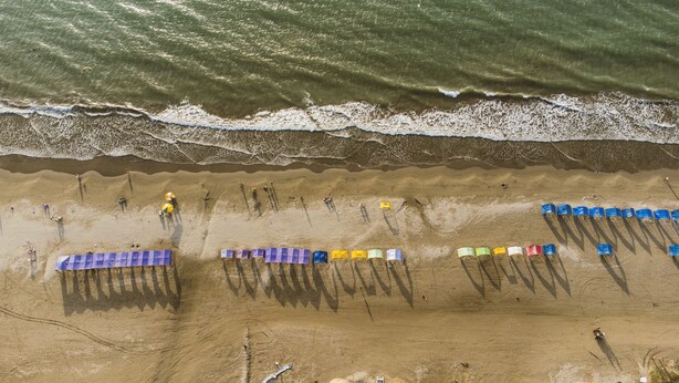 An aerial view of a beach with people, umbrellas, and beach chairs. - HOTEL SUNSET BEACH (Cartagena)