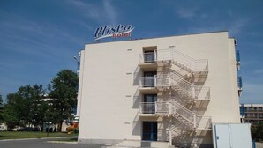 A hotel named Pliska with a white facade, multiple balconies, and a blue door. - Hotel Pliska (Nessebar)