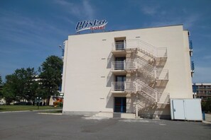 A hotel named Pliska with a white facade, multiple balconies, and a blue door.