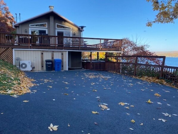 Une maison dotée d’un porche abrité, d’un garage et offrant une vue sur l’eau.
