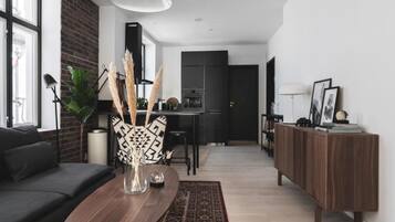 A modern living room with a dark sofa, a wooden coffee table, and a decorative vase.