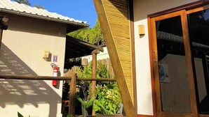 A two-story building with a wooden staircase leading to an upper balcony. - VILLA CRIS (Fernando de Noronha)