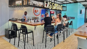 A bar area with a counter, stools, and a sign reading "LAS SIRENAS". - Hotel Citadin Z4 (Guatemala City)