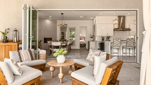 A modern living room with a sofa set, a coffee table, and a dining area with a table and chairs.