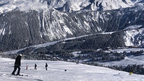 A snowy mountain landscape with skiers and a ski resort in the foreground. - 2 bed Apt in Courchevel 1650, Doorstep skiing - Courchevel, Meribel, Val Thorens (Courchevel)