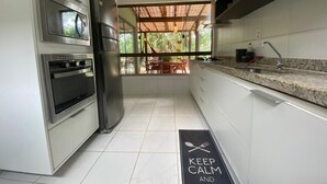 A modern kitchen with stainless steel appliances, a granite countertop, and a view of the outdoors.
