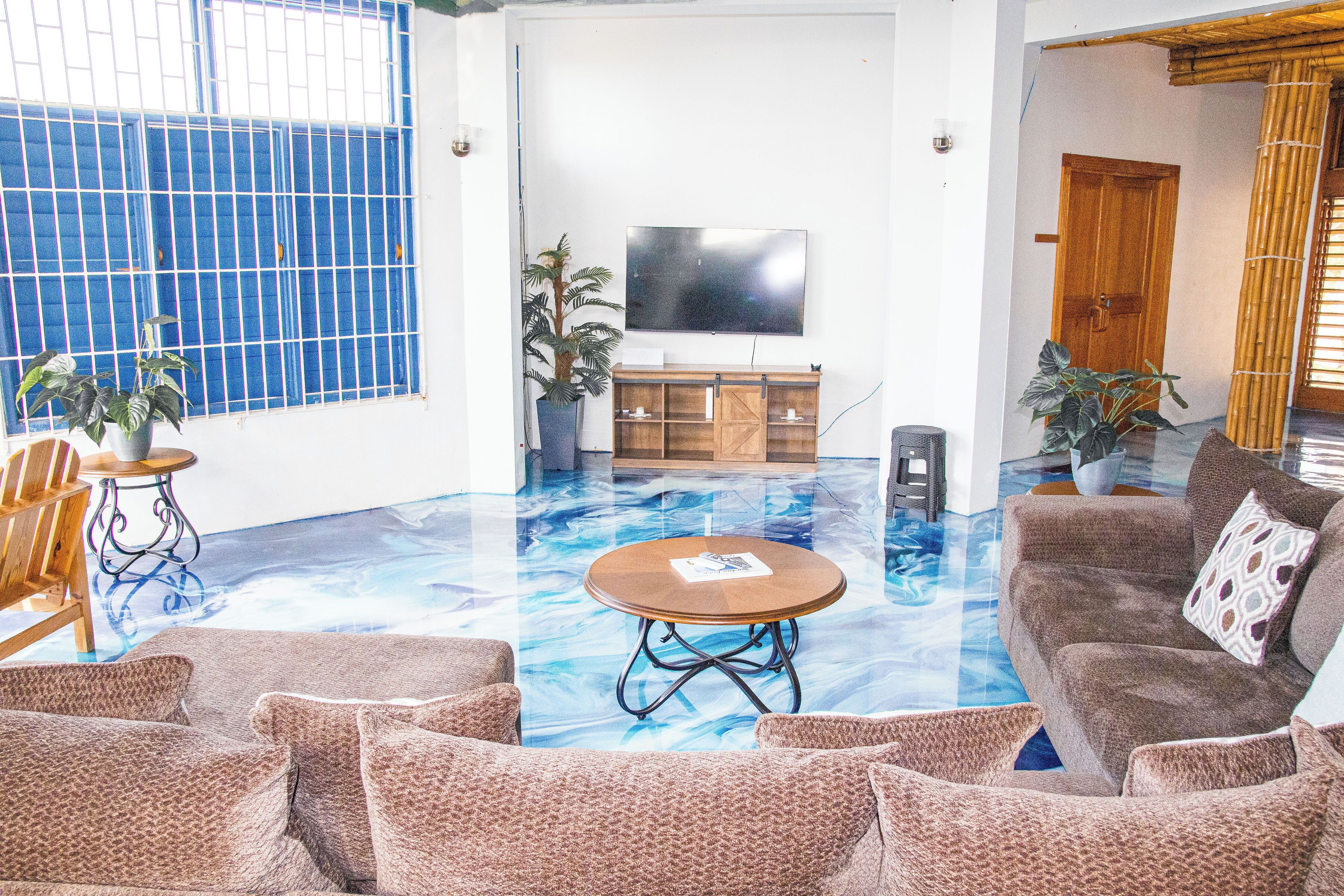 A living room with a large window, a flat-screen TV, a sofa, and a coffee table.