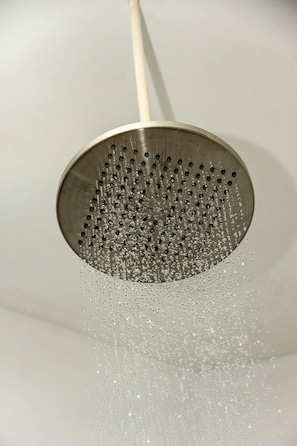 Un pommeau de douche d'où jaillit de l'eau.