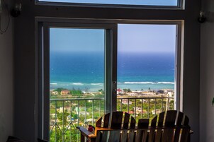Una habitación con vista al océano a través de un amplio ventanal.