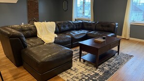 Una sala de estar moderna con un sofá modular, una mesa de centro y una alfombra estampada.